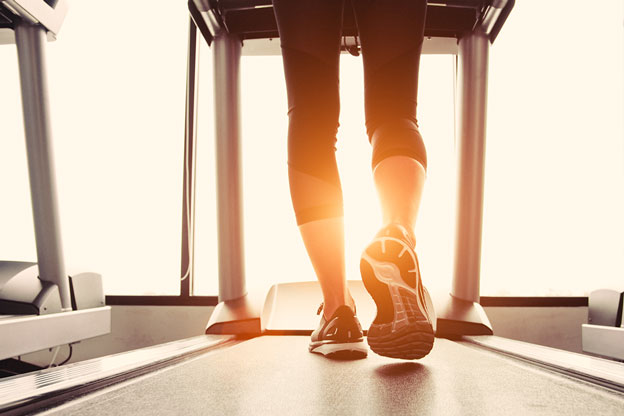 a female running on a treadmill with the sun in front of her